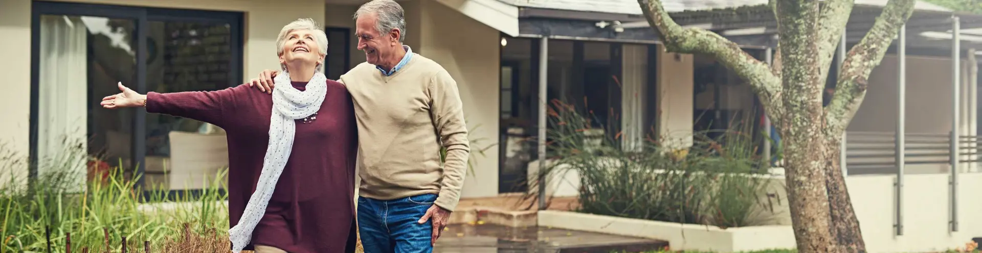 Residential Mortgages - Home Loans - Senior Couple Outside In Front Yard in the Rain
